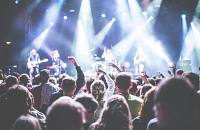 A crowd cheering a band at an event.