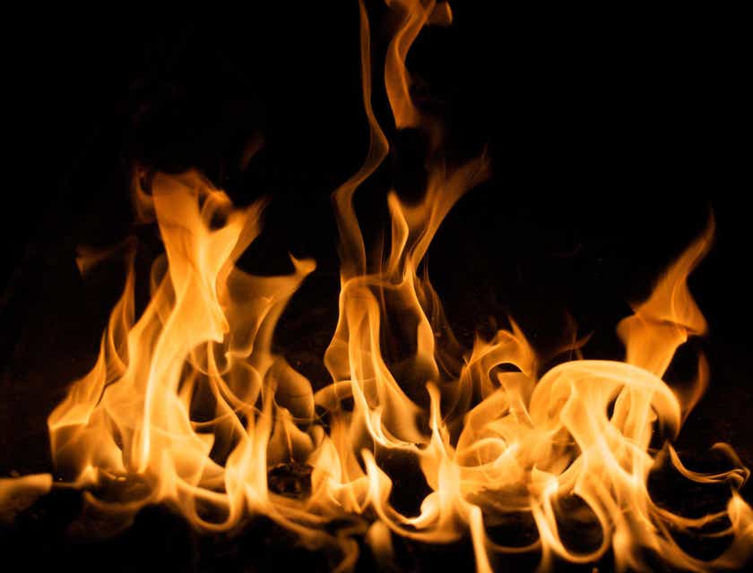 Die Flammen eines lodernden Feuers tänzeln in einem offenen Kamin.
