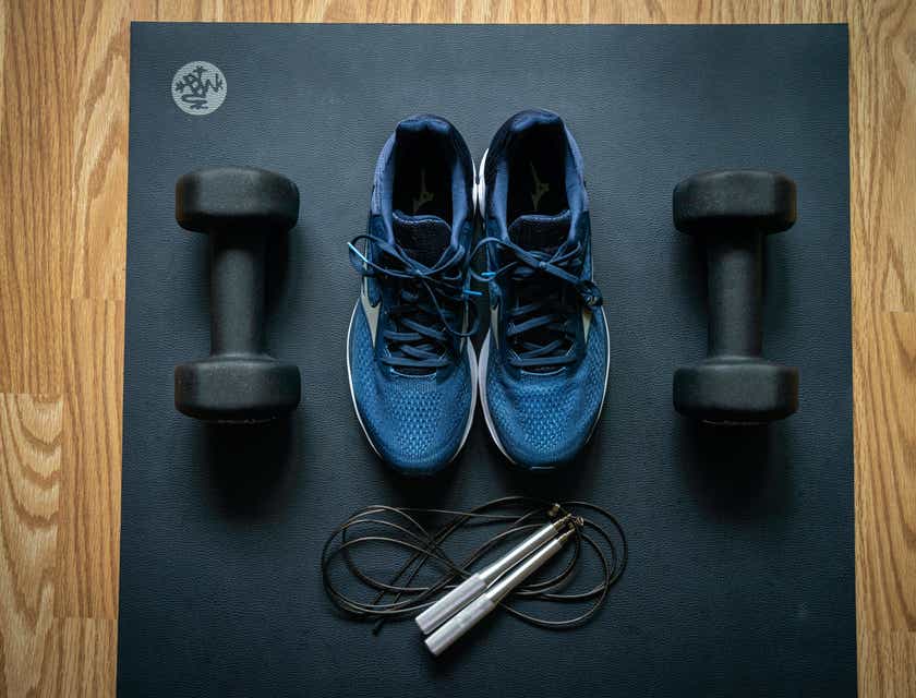 Perlengkapan fitness dipajang di sebelah sepasang sepatu olahraga.