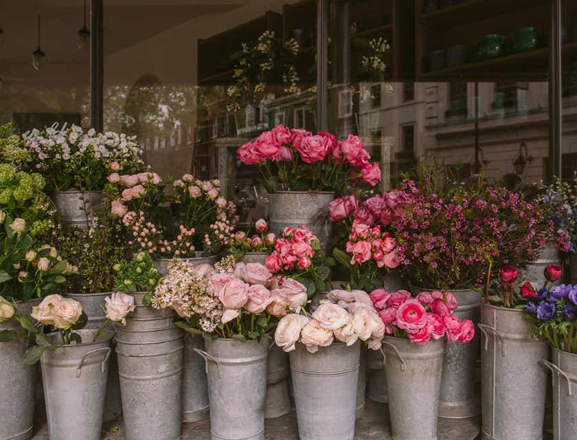 Bermacam-macam bunga berwarna-warni dalam pot di luar sebuah toko bunga.