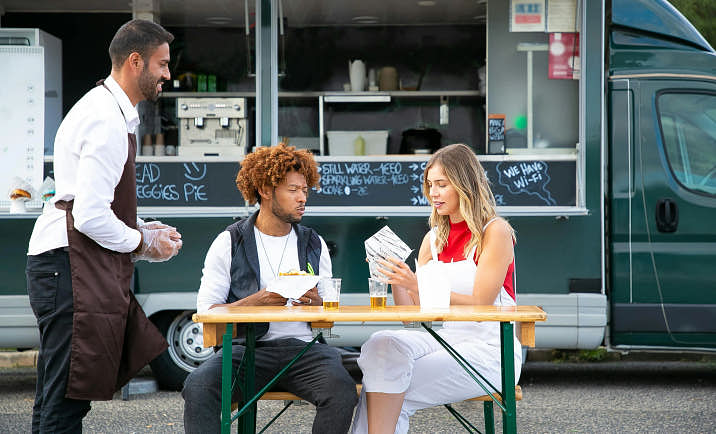 People sitting outside a food truck.