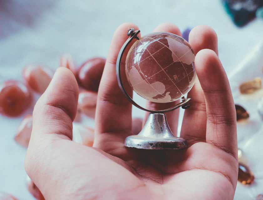 Une personne tenant un mini globe terrestre dans ses mains.