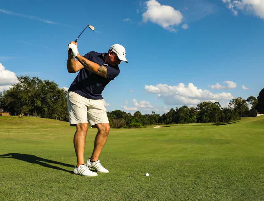 Un hombre jugando al golf en un día soleado.