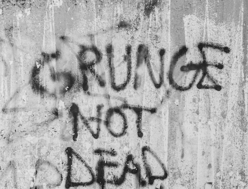 Un graffiti en la pared que dice: “el grunge no ha muerto”, en un logo grunge.
