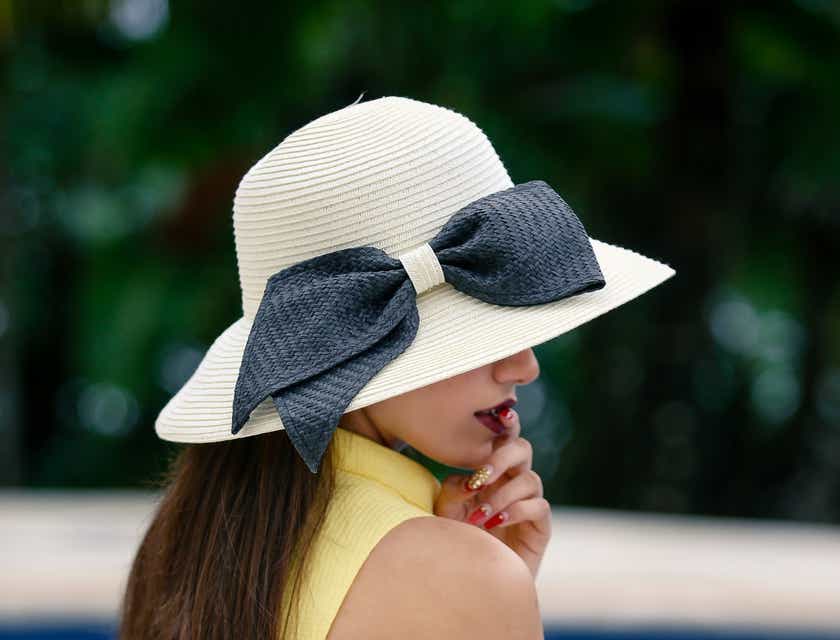 Una donna che indossa un cappello di paglia con un fiocco.
