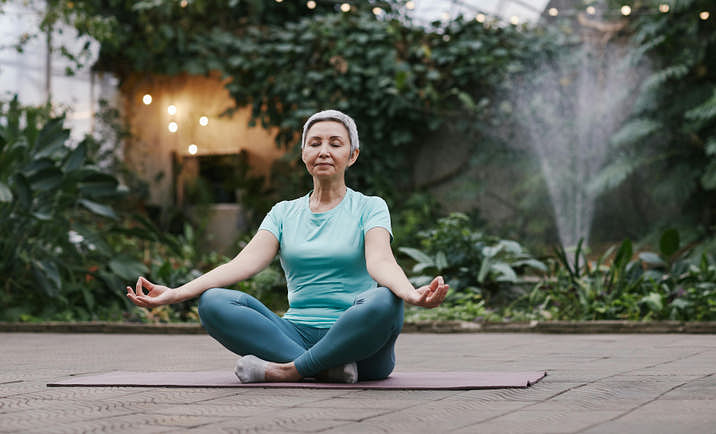 A person practicing health and wellness through yoga in an outdoor area.