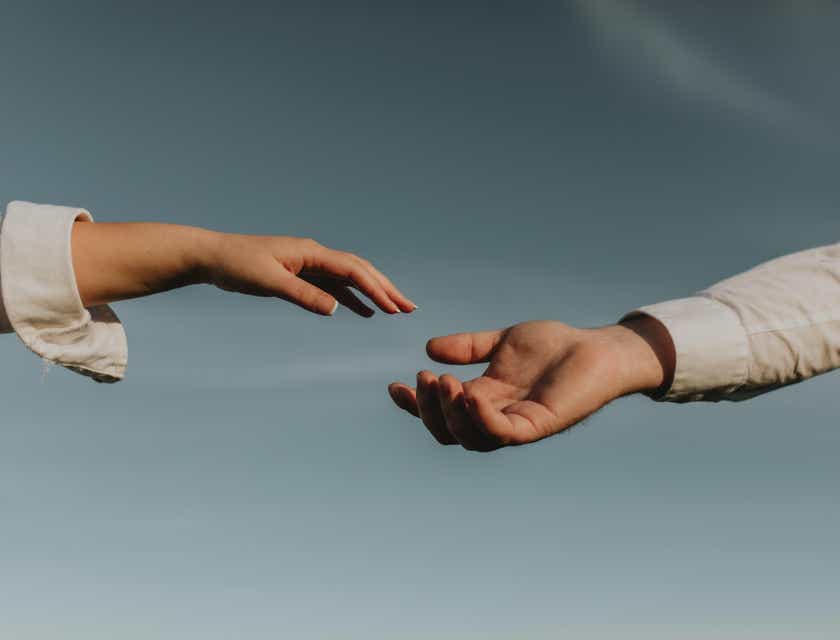 Una persona ofreciendo una mano amiga a otra en un logo de ayuda.