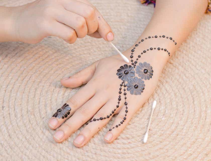 Ein Henna-Tattoo wird in einem Henna-Studio auf eine Hand aufgetragen.