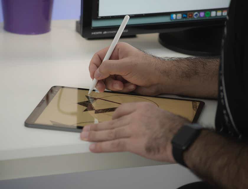Iemand die met de hand een logo design ontwerpt op een tablet.