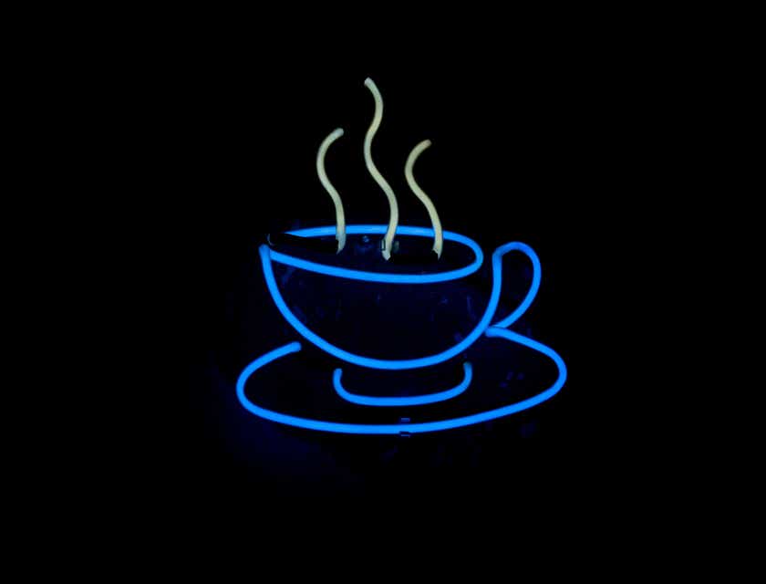 Una taza de café humeante con luces de neón en un logo candente.