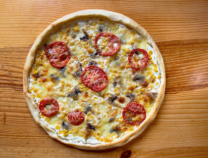 Beautiful pizza on a wooden table at a pizza shop.