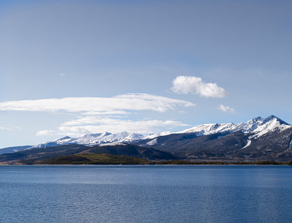 Snow-covered mountains surrounded by a body of water in Colorado.