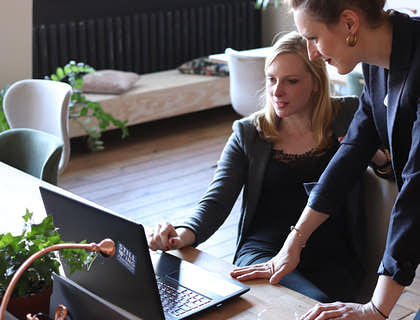 Two women looking at a laptop screen.