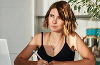 A woman sitting at her desk, writing a slogan.