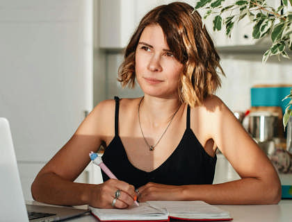A woman sitting at her desk, writing a slogan.