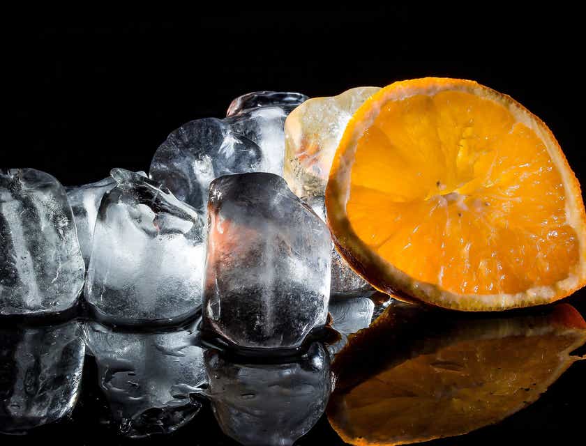 Blocks of ice with an orange slice on a black background.