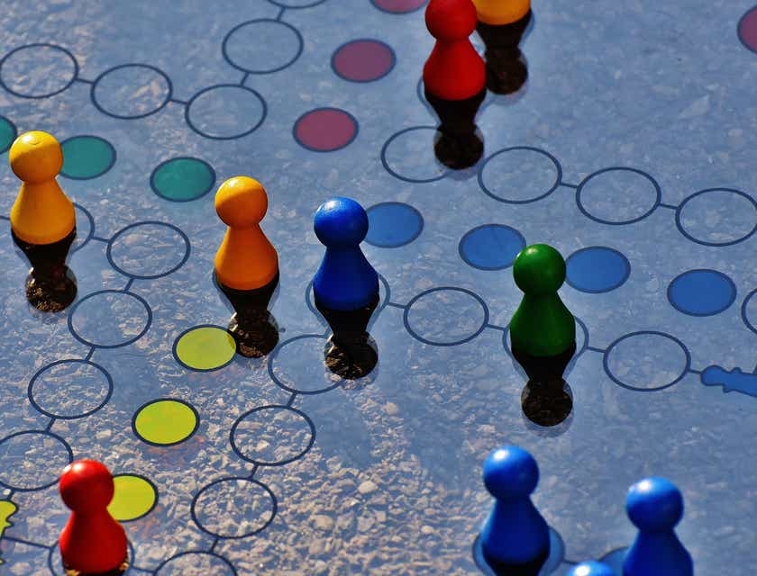 Figuras de colores sobre un tablero de juego de mesa.