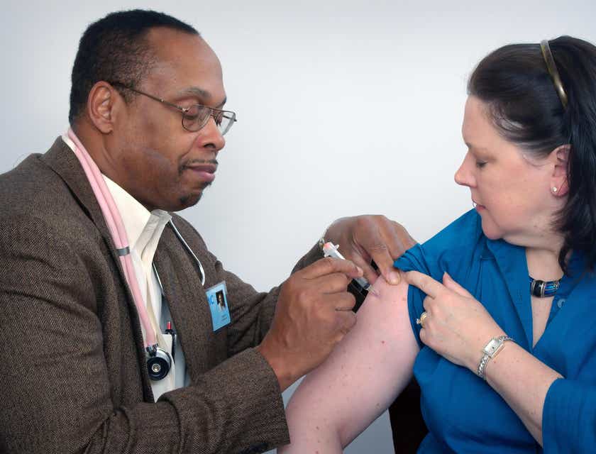 Médico inyectando la parte superior del brazo a una paciente en un consultorio en un logo para medicina interna.