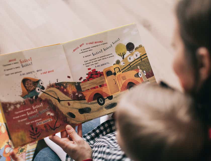 Een medewerker van een kinderopvang die een boek voorleest aan een kleuter.