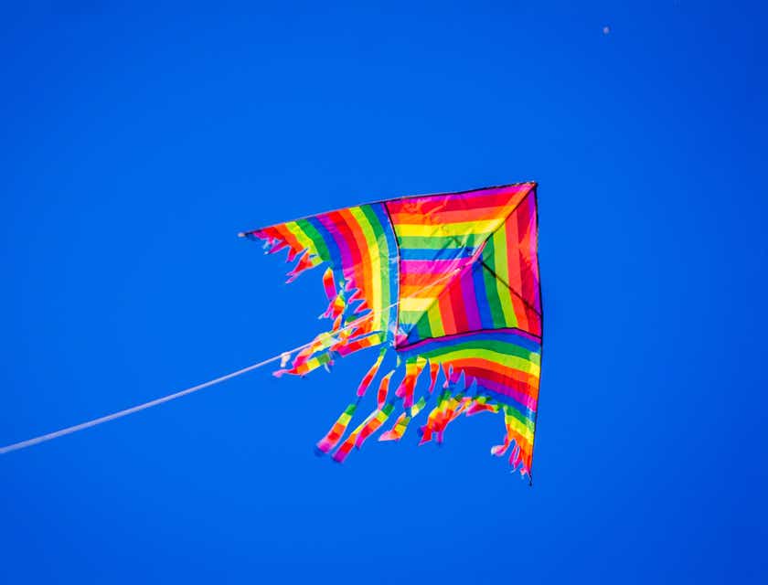 A flying kite decorated in rainbow colors.