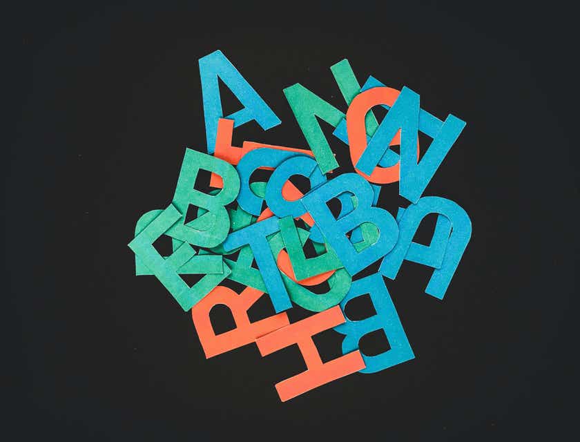 Une pile de lettres colorées pour des logos affichés sur une surface noire.