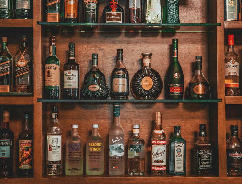 Bottles of liquor on a wooden shelf.