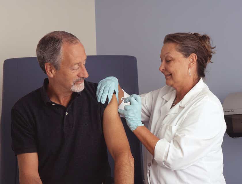 Seorang perawat menyuntikkan vaksin ke lengan pasien.