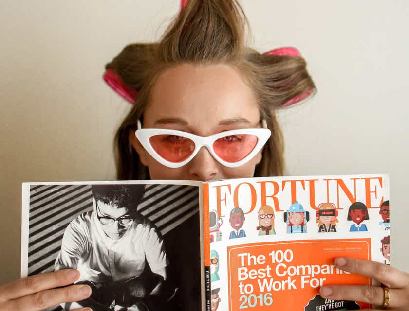 Seorang gadis muda memegang majalah trendi.