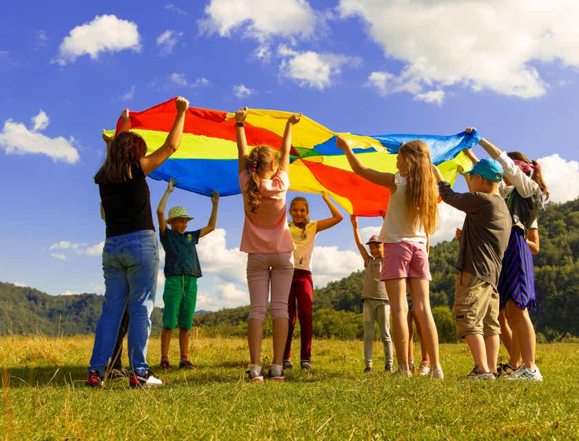 Un grupo de niñas y niños jugando al aire libre en un logo amigable para niños.