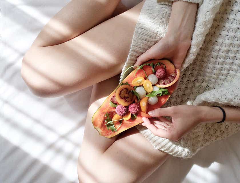 Une femme prenant soin de sa santé en mangeant une salade de fruits nutritive.