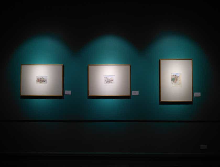 Tres marcos de fotos iluminados en una pared azul oscuro.