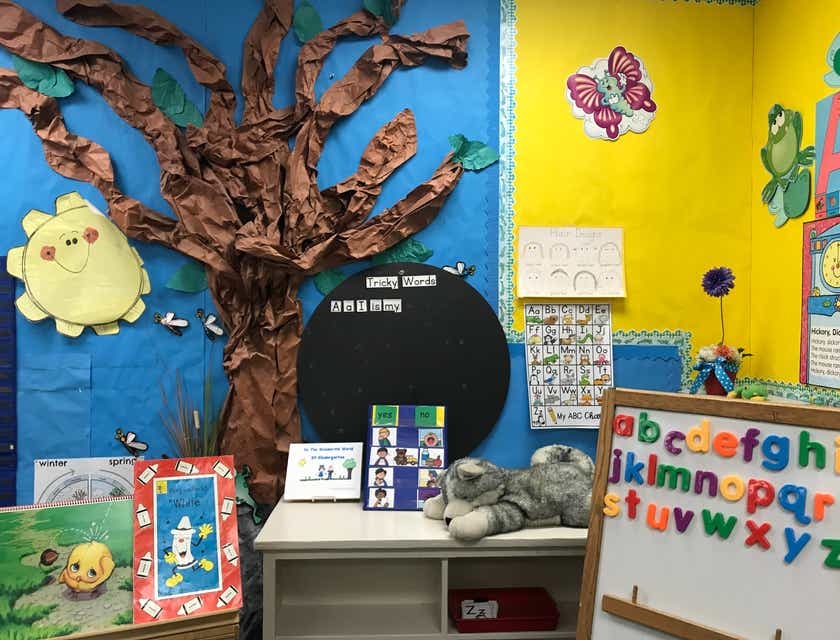 Un salón de clases de preescolar con imágenes coloridas en la pared y varias ayudas educativas alrededor del salón en un logo para preescolar.