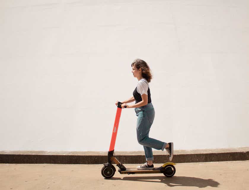 Una mujer patinando en un scooter eléctrico.