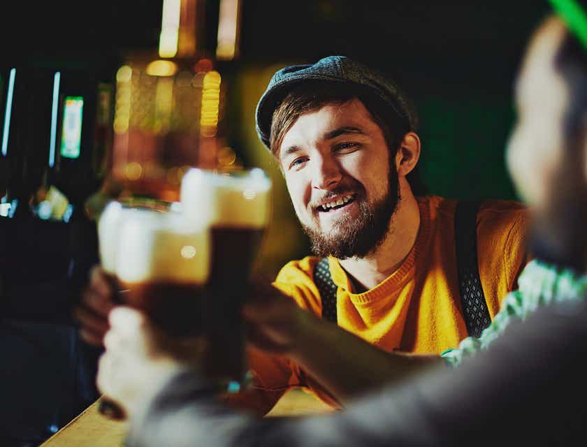 Tres amigos brindando con cerveza en el logo de una taberna.