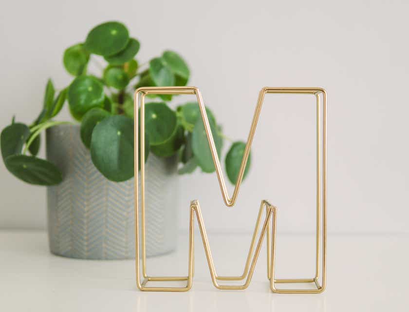 Złota ozdoba na biurko w kształcie litery „M”.
