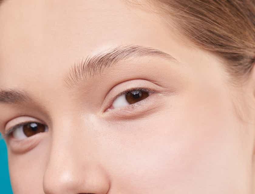 A woman showing off her eyebrows after a microblading session.
