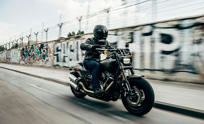 Person in dark clothes driving a motorcycle at high speed.