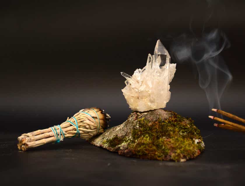 Mistyczna kompozycja płonącego kadzidła, gałązki szałwii i kryształów.
