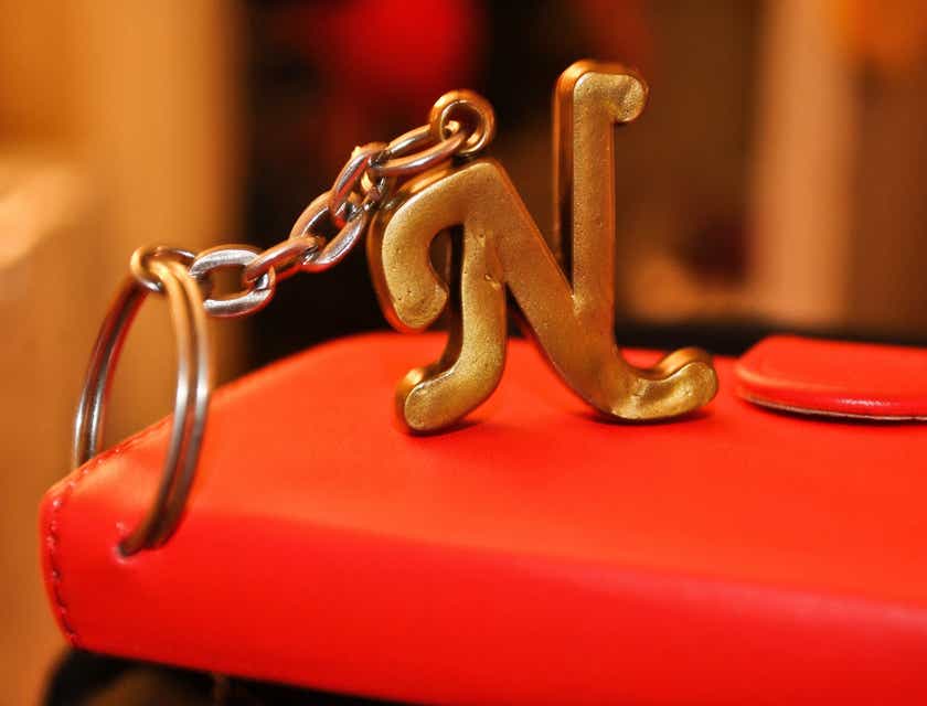 Un portachiavi a forma di lettera "N" attaccato a un portafoglio rosso.