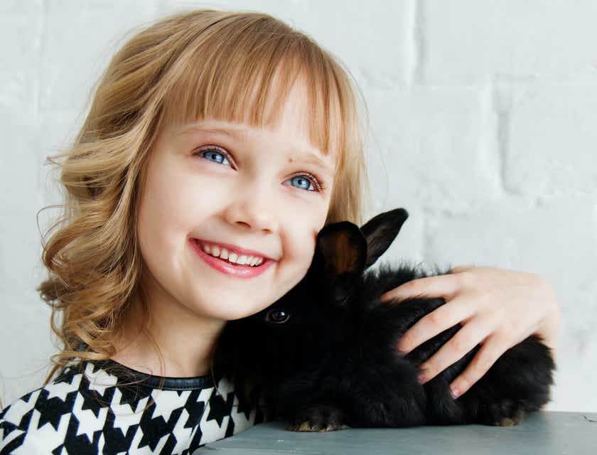 Una agradable imagen de una niña y un conejo.