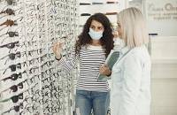 An optician advising a customer on eyewear frames.