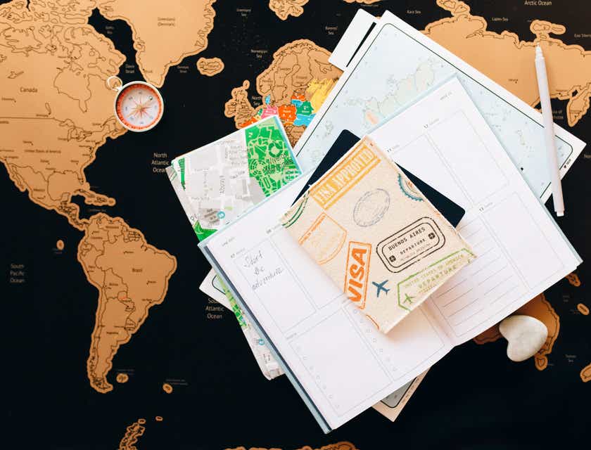 A view of a passport and visa displayed with a map and travel journal.