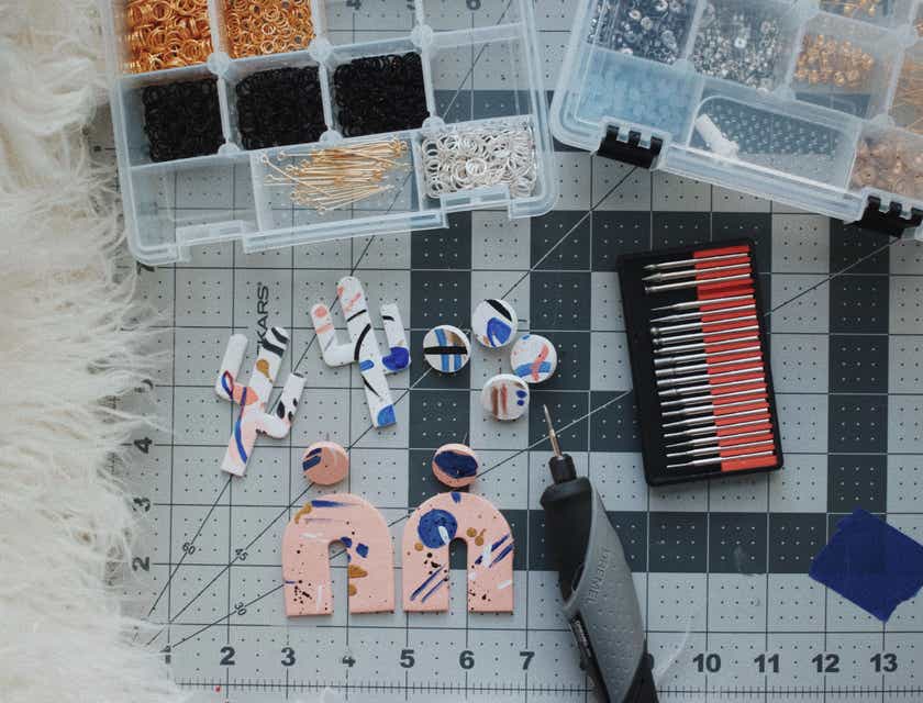 Tools used to make polymer clay earrings alongside completed earrings.