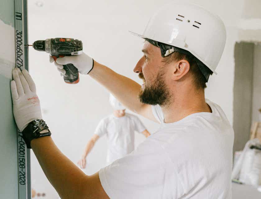 Un travailleur souriant effectuant des rénovations chez une personne.
