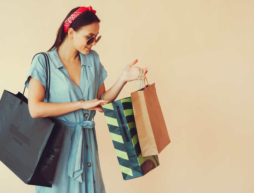 Eine Frau mit Einkaufstüten nach einer Shoppingtour bei verschiedenen Einzelhändlern.