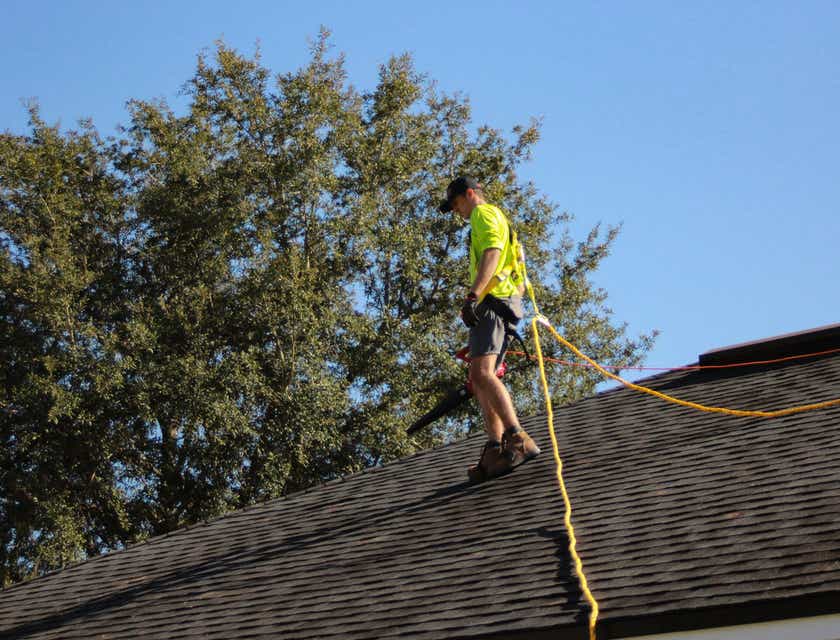 Un trabajador instalando paneles solares en un techo en un logo de techos.