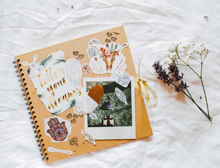 A scrapbook displayed on a white sheet next to a floral accent.