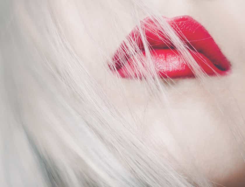 Rambut pirang seorang wanita tertiup melewati bibir merahnya yang seksi.
