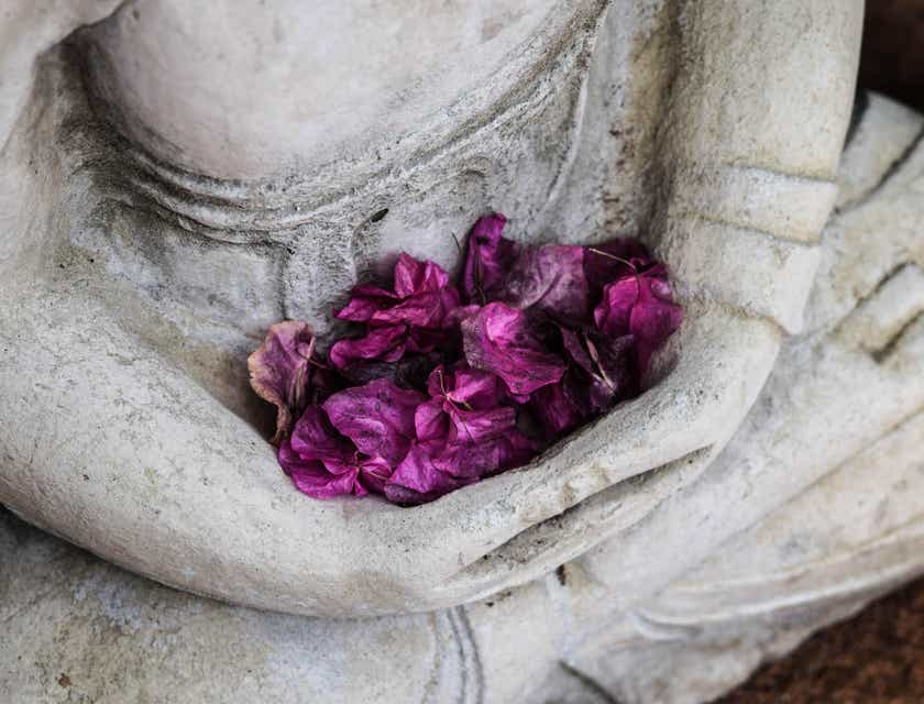 Des fleurs violettes dans les bras d'une statue.
