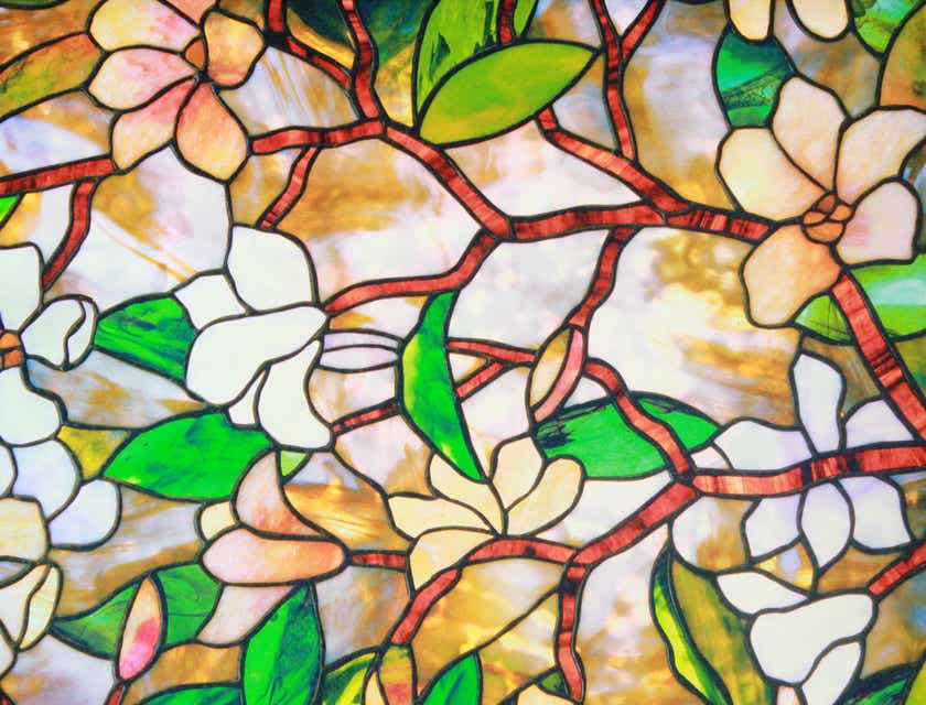 A stained glass window with images of flowers, branches, and leaves.